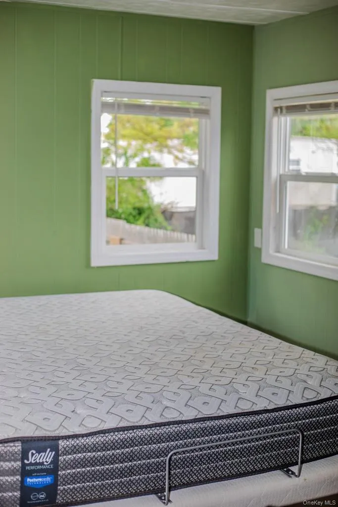 primary bedroom with many windows allowing sunlight primary bedroom with many windows allowing sunlight