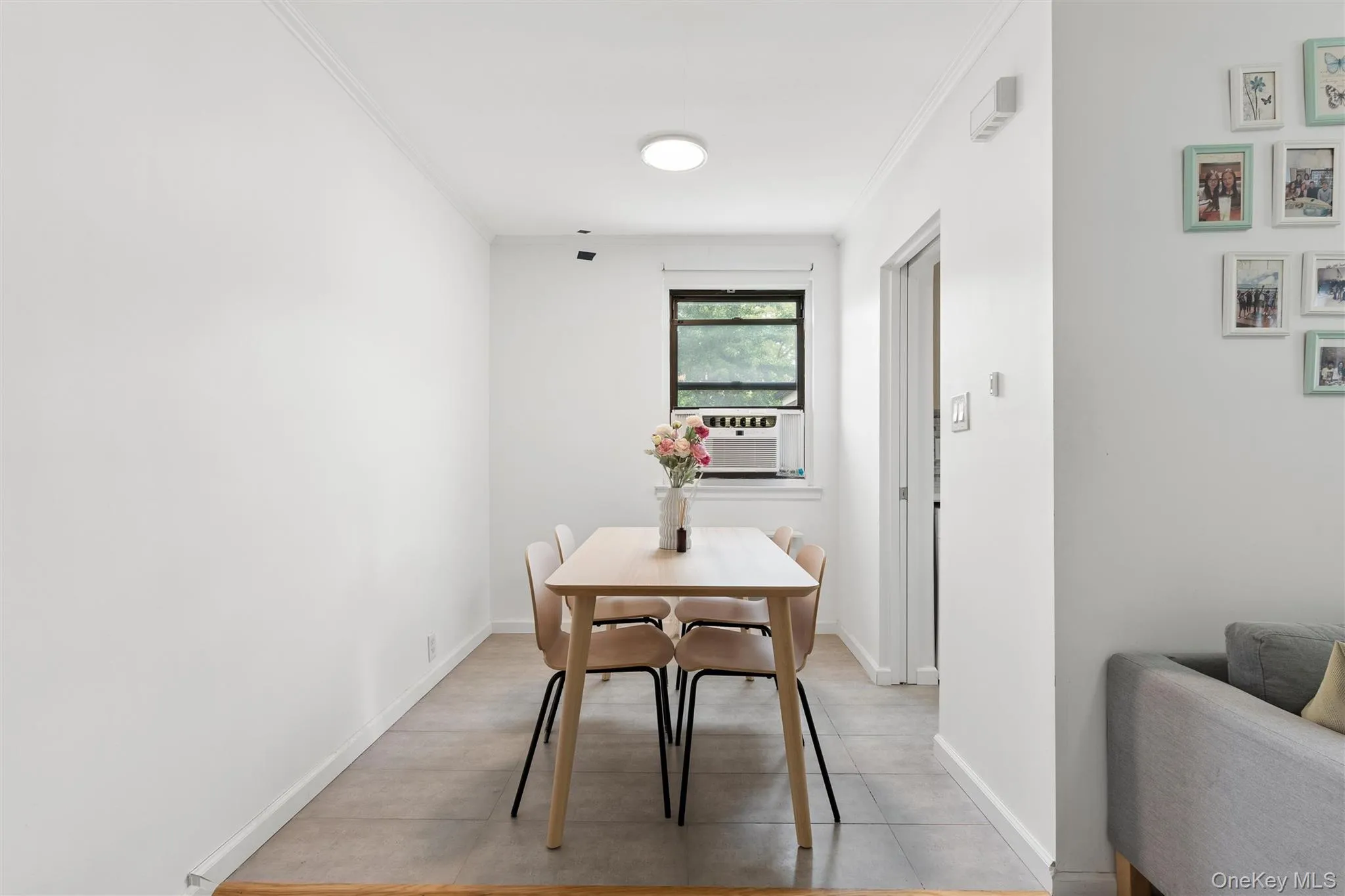 Bright Dining room, a window-mounted air conditioning unit, and light-toned tile flooring Bright Dining room, a window-mounted air conditioning unit, and light-toned tile flooring