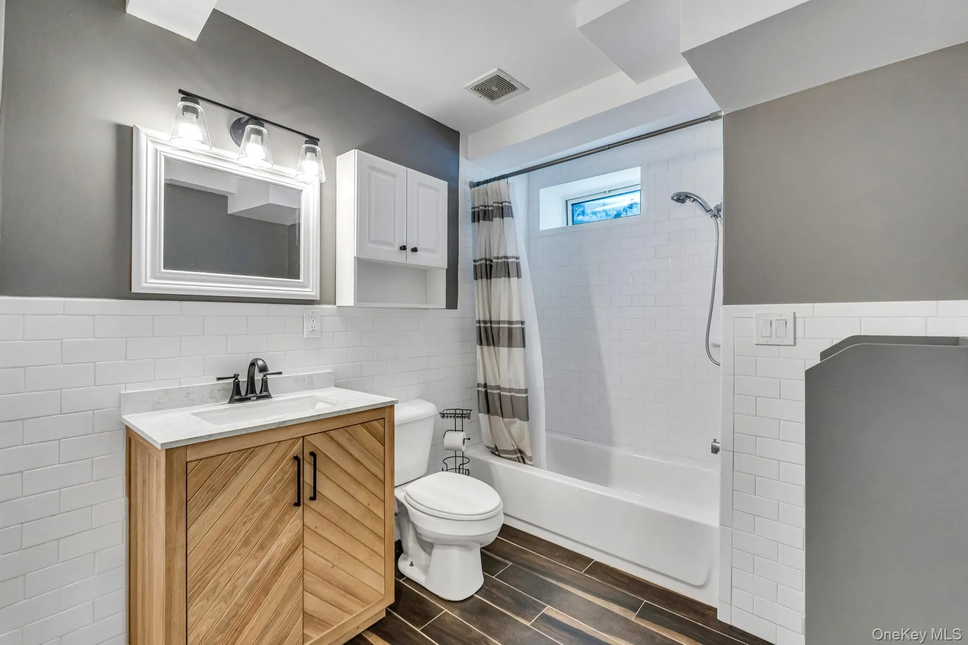 Bathroom featuring a modern wood-finish vanity with a white countertop and rectangular undermount sink Bathroom featuring a modern wood-finish vanity with a white countertop and rectangular undermount sink