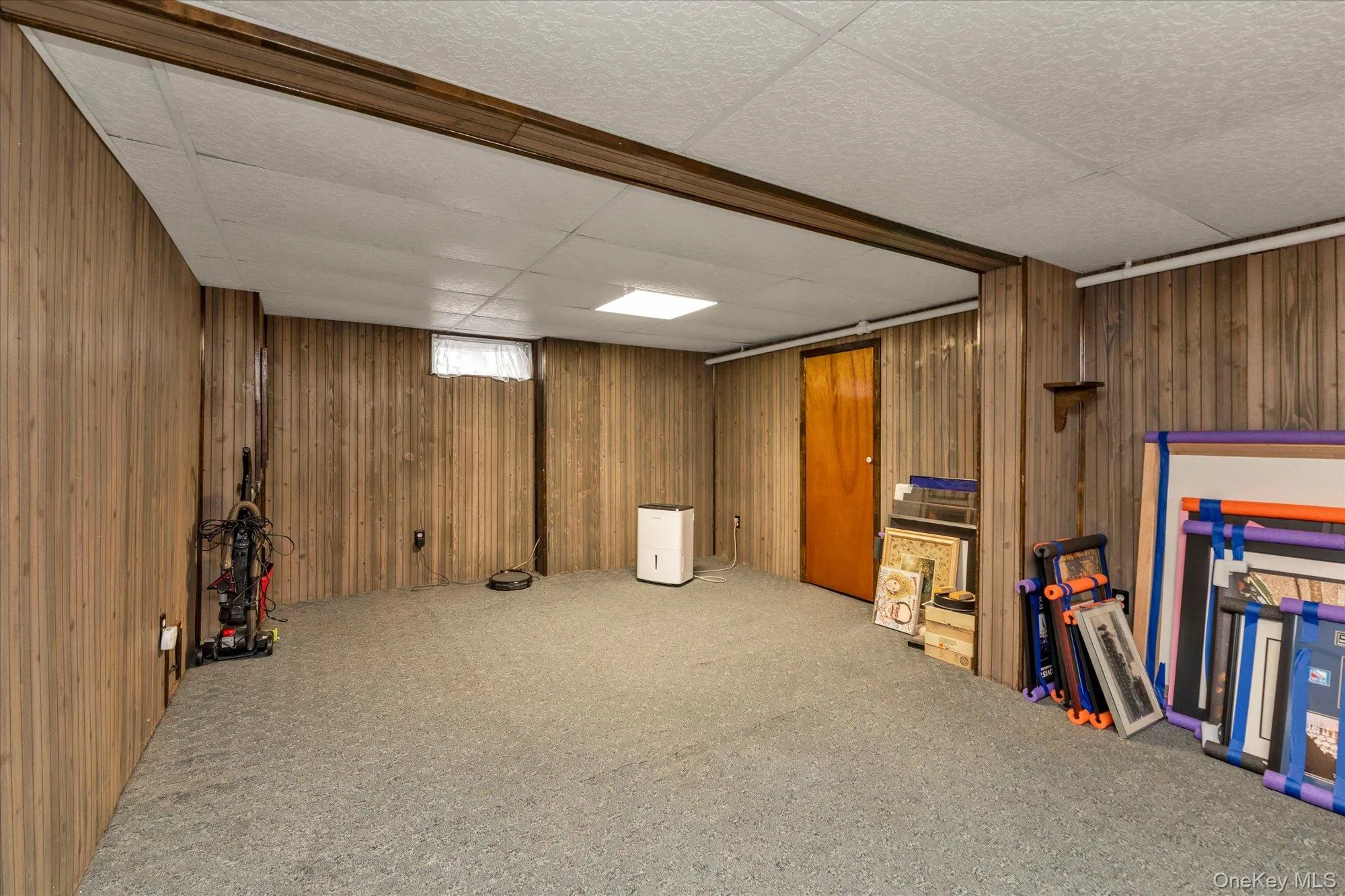 Carpeted recreation room featuring wood paneling and recessed lighting. Carpeted recreation room featuring wood paneling and recessed lighting.