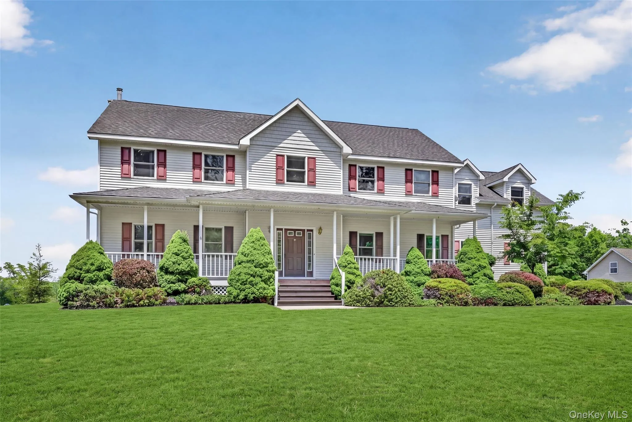 Colonial-style residence featuring light gray siding with red shutters and a dark shingle roof Colonial-style residence featuring light gray siding with red shutters and a dark shingle roof