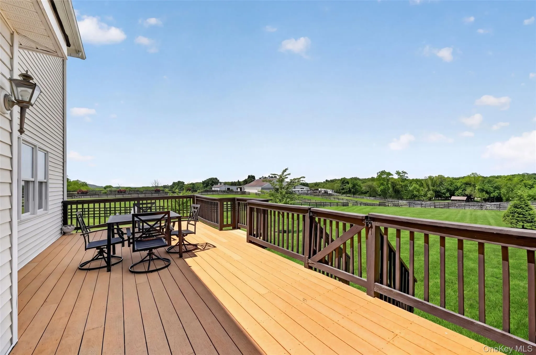 Expansive outdoor deck featuring composite decking and dark wood railings Expansive outdoor deck featuring composite decking and dark wood railings