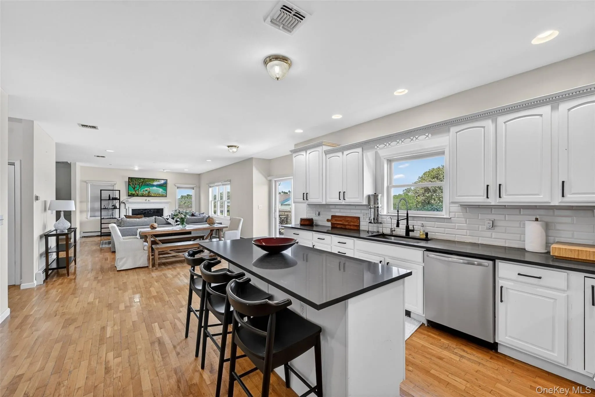 Kitchen with white cabinetry, black Granite countertops, and stainless steel appliances Kitchen with white cabinetry, black Granite countertops, and stainless steel appliances