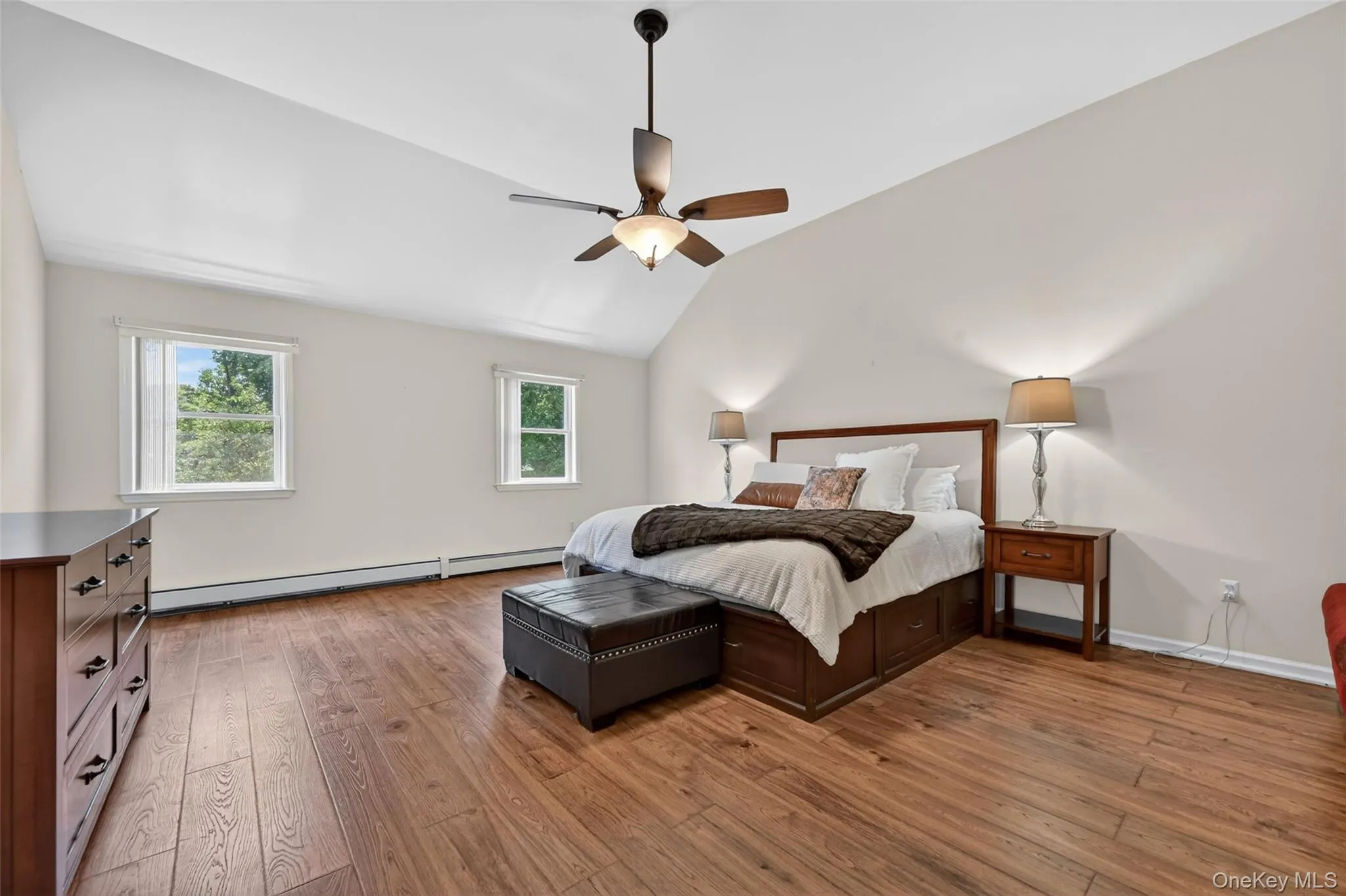 Vaulted ceiling bedroom featuring wood-finish flooring, recessed windows, and a ceiling fan with integrated lighting Vaulted ceiling bedroom featuring wood-finish flooring, recessed windows, and a ceiling fan with integrated lighting