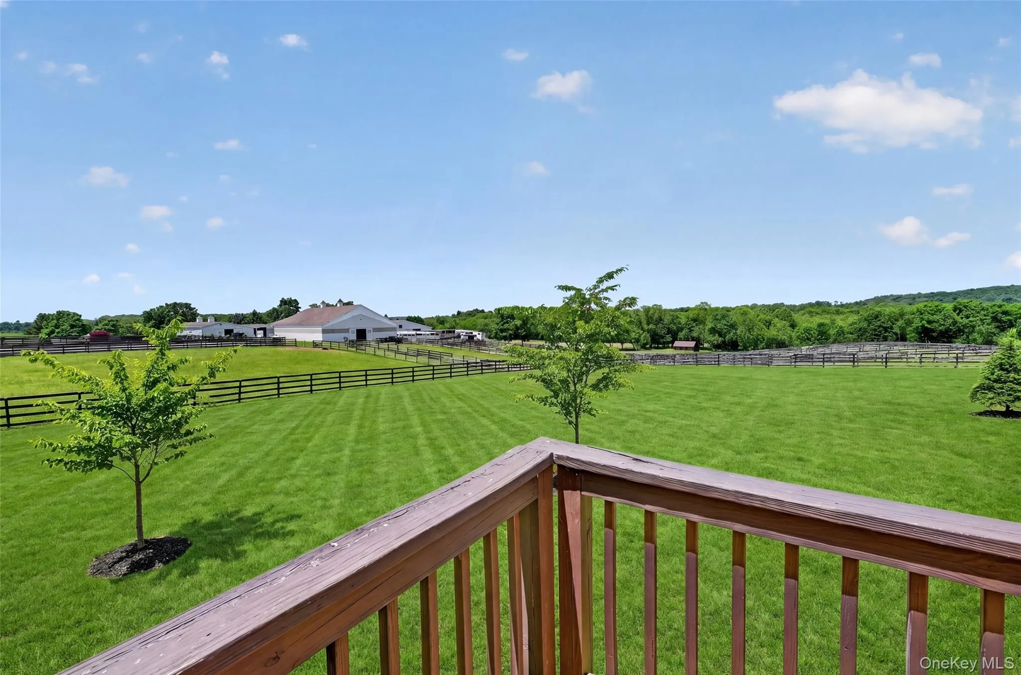 View from deck of Expansive grounds featuring a large barn structure and fenced pastures View from deck of Expansive grounds featuring a large barn structure and fenced pastures
