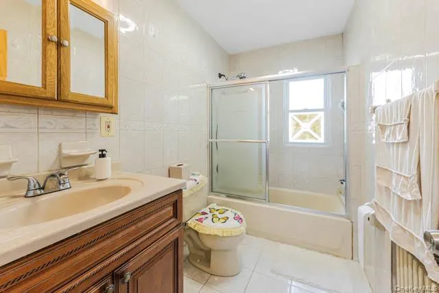 Bathroom featuring a wood-finish vanity with an integrated sink and mirror-front medicine cabinet Bathroom featuring a wood-finish vanity with an integrated sink and mirror-front medicine cabinet