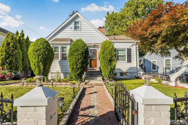 Cape Cod style residence featuring white siding and a prominent front gable Cape Cod style residence featuring white siding and a prominent front gable