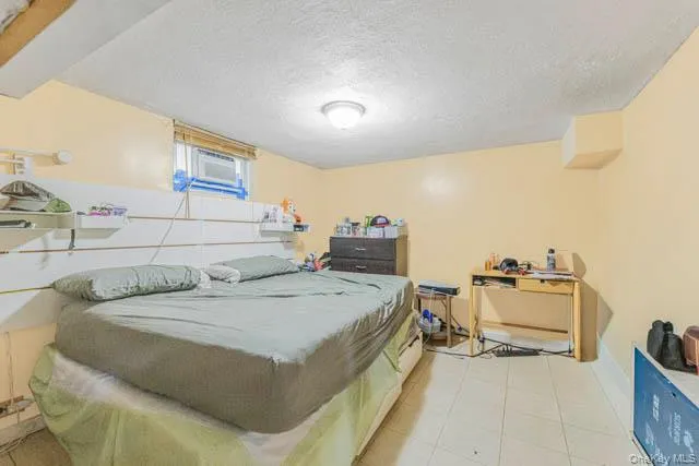 Room featuring light-colored walls, white ceiling, and tiled flooring Room featuring light-colored walls, white ceiling, and tiled flooring