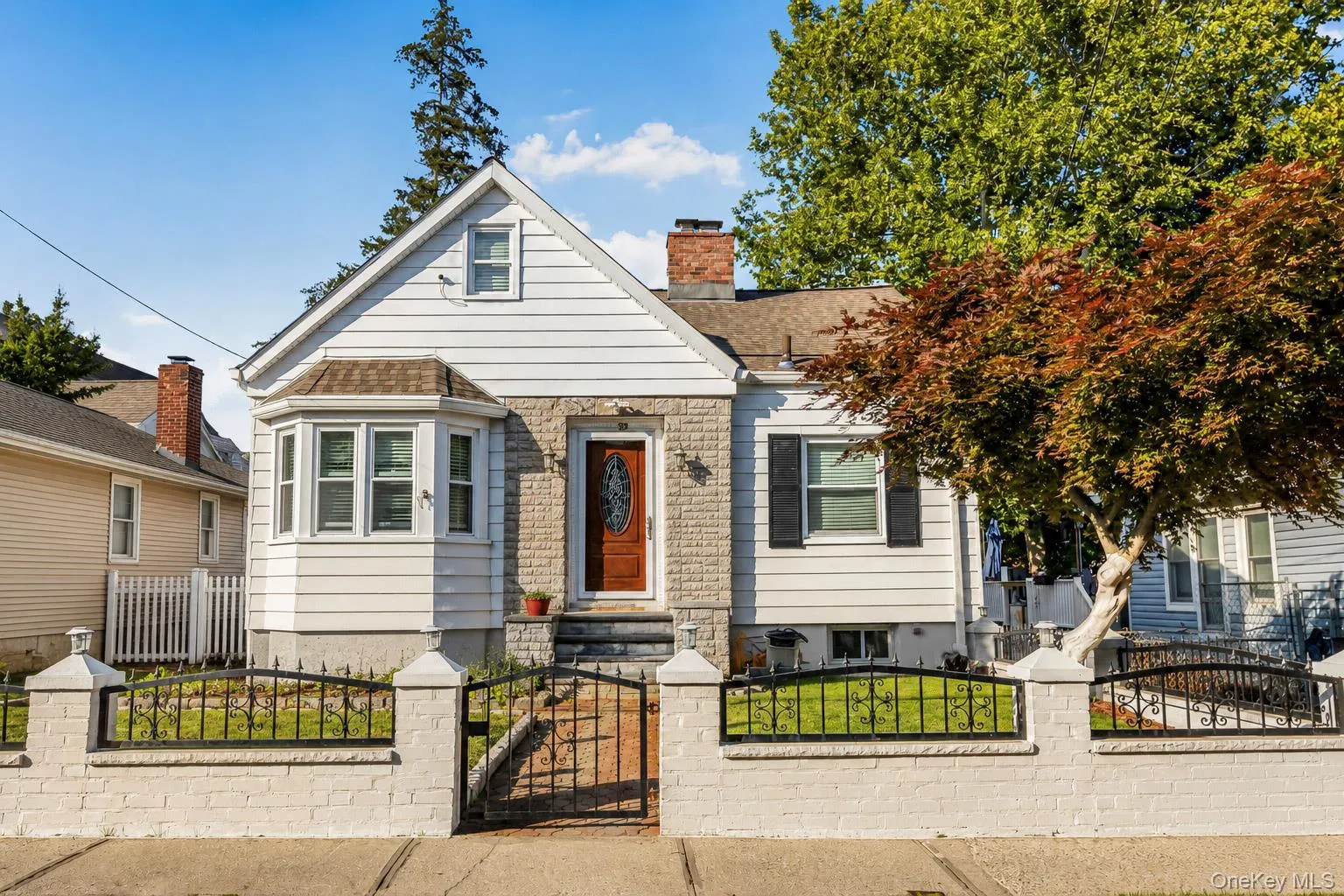 Charming bungalow with a light-colored wood-paneled facade and stone accents Charming bungalow with a light-colored wood-paneled facade and stone accents