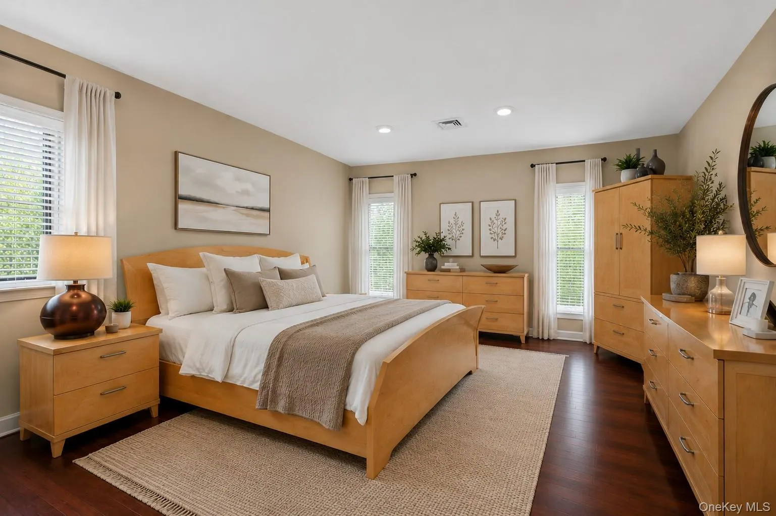 The expansive primary suite serves as a peaceful retreat, featuring three window exposures that flood the space with natural light. Generous proportions easily accommodate multiple furniture arrangements and are complemented by a dedicated dressing/vanity area, walk-in closet, and private primary bath. The expansive primary suite serves as a peaceful retreat, featuring three window exposures that flood the space with natural light. Generous proportions easily accommodate multiple furniture arrangements and are complemented by a dedicated dressing/vanity area, walk-in closet, and private primary bath.