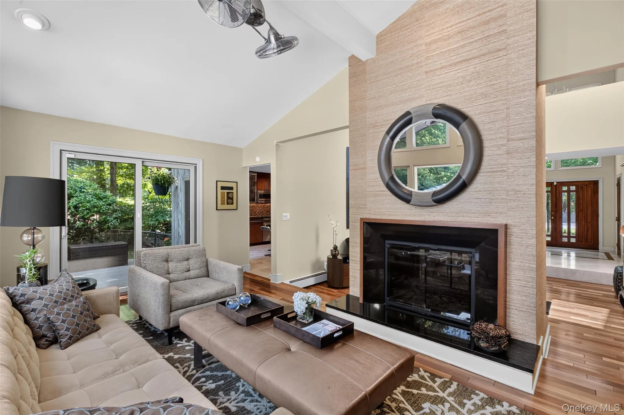 A striking double-sided wood-burning fireplace serves as the room's focal point, while rich Brazilian cherry hardwood floors add warmth and elegance. Sliding glass doors provide seamless access to the deck, pool, and outdoor entertaining areas, creating an exceptional indoor-outdoor lifestyle. A striking double-sided wood-burning fireplace serves as the room's focal point, while rich Brazilian cherry hardwood floors add warmth and elegance. Sliding glass doors provide seamless access to the deck, pool, and outdoor entertaining areas, creating an exceptional indoor-outdoor lifestyle.