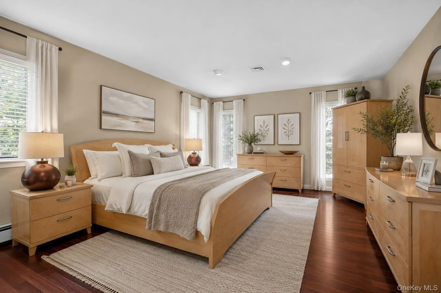 The expansive primary suite serves as a peaceful retreat, featuring three window exposures that flood the space with natural light. Generous proportions easily accommodate multiple furniture arrangements and are complemented by a dedicated dressing/vanity area, walk-in closet, and private primary bath. The expansive primary suite serves as a peaceful retreat, featuring three window exposures that flood the space with natural light. Generous proportions easily accommodate multiple furniture arrangements and are complemented by a dedicated dressing/vanity area, walk-in closet, and private primary bath.