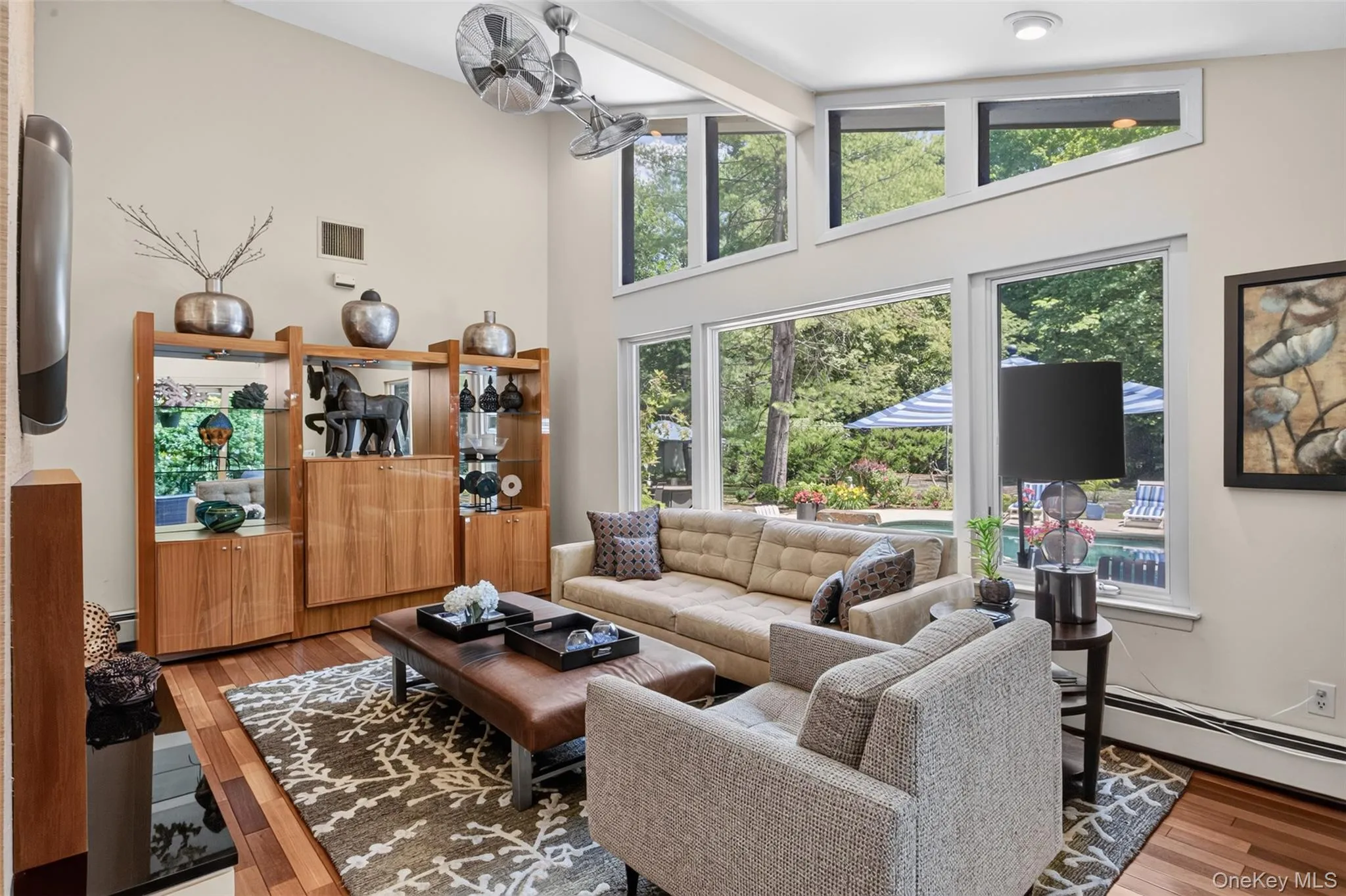 The expansive family room is designed to bring the outdoors in, featuring a dramatic wall of windows that fills the space with natural light and showcases views of the surrounding property. The expansive family room is designed to bring the outdoors in, featuring a dramatic wall of windows that fills the space with natural light and showcases views of the surrounding property.