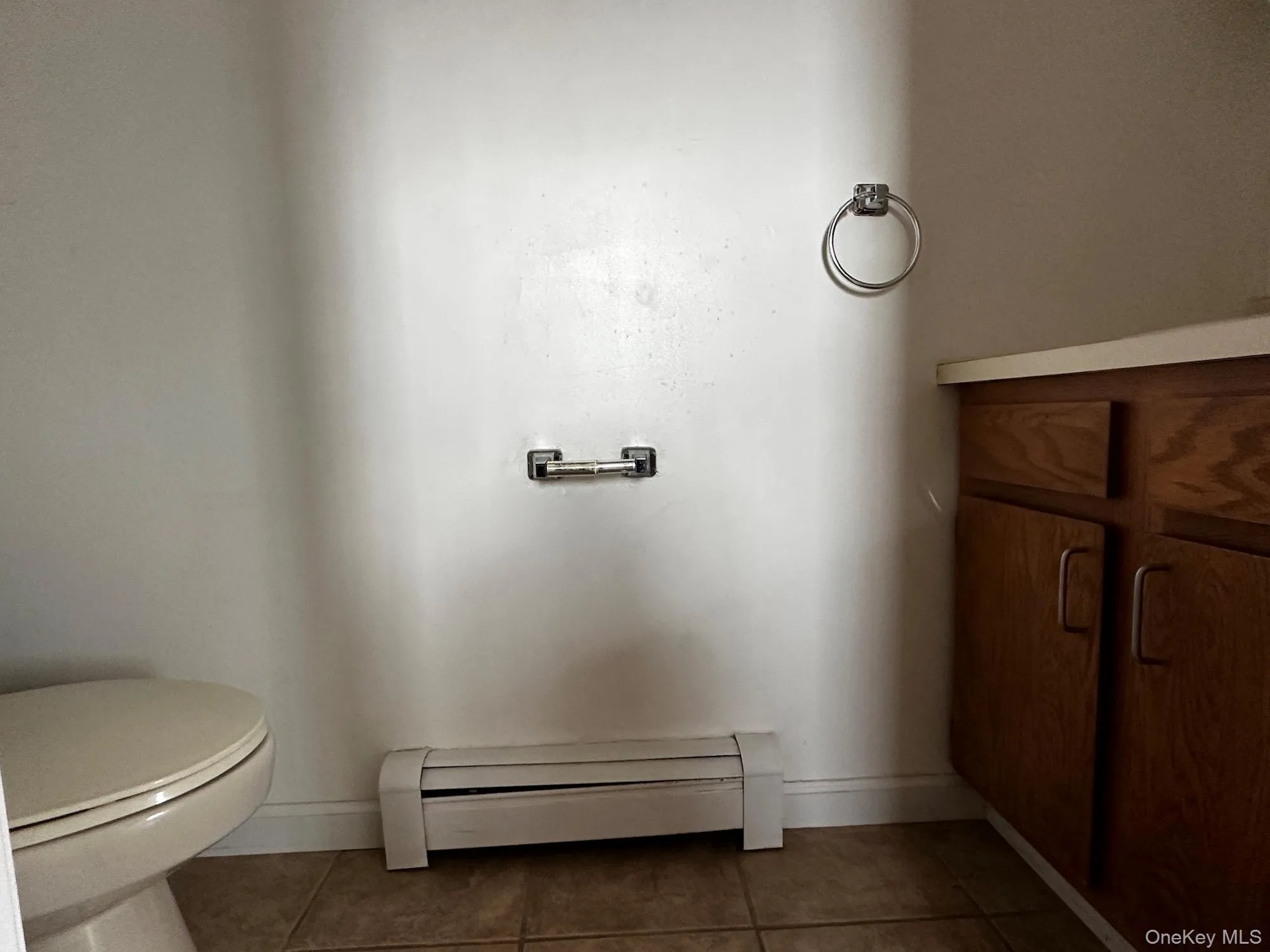 Bathroom featuring baseboard heating, tile patterned flooring, and vanity Bathroom featuring baseboard heating, tile patterned flooring, and vanity