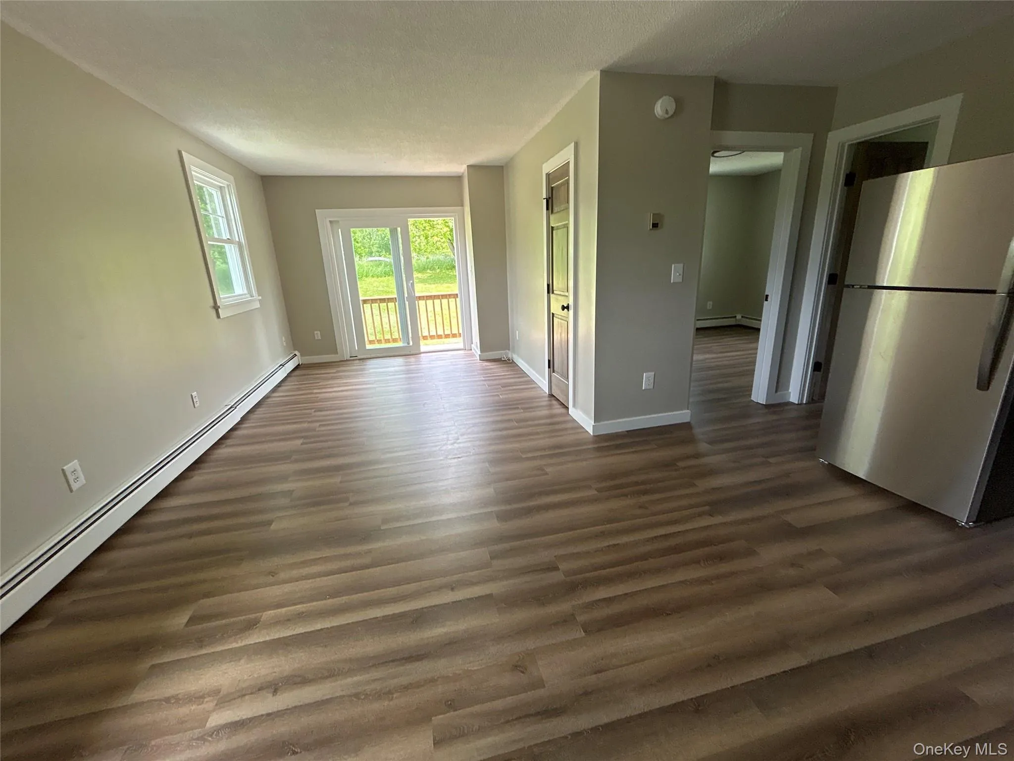 Second floor one bedroom apartment #3 view from dining room into living room with a balcony Second floor one bedroom apartment #3 view from dining room into living room with a balcony