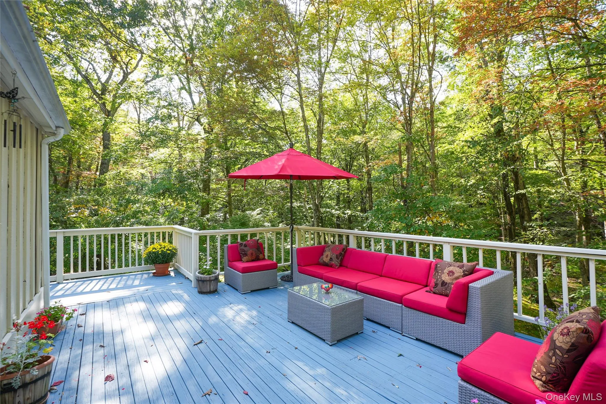 Expansive outdoor deck with light blue wood-finish flooring and white railing Expansive outdoor deck with light blue wood-finish flooring and white railing