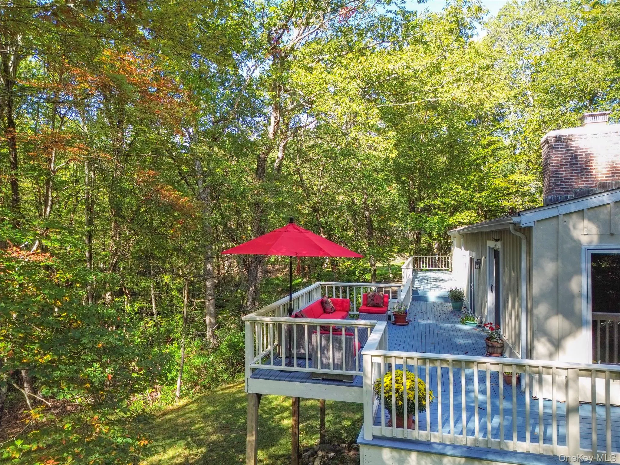 Spacious wrap around deck with white railing, light gray composite decking, and a tan exterior facade Spacious wrap around deck with white railing, light gray composite decking, and a tan exterior facade