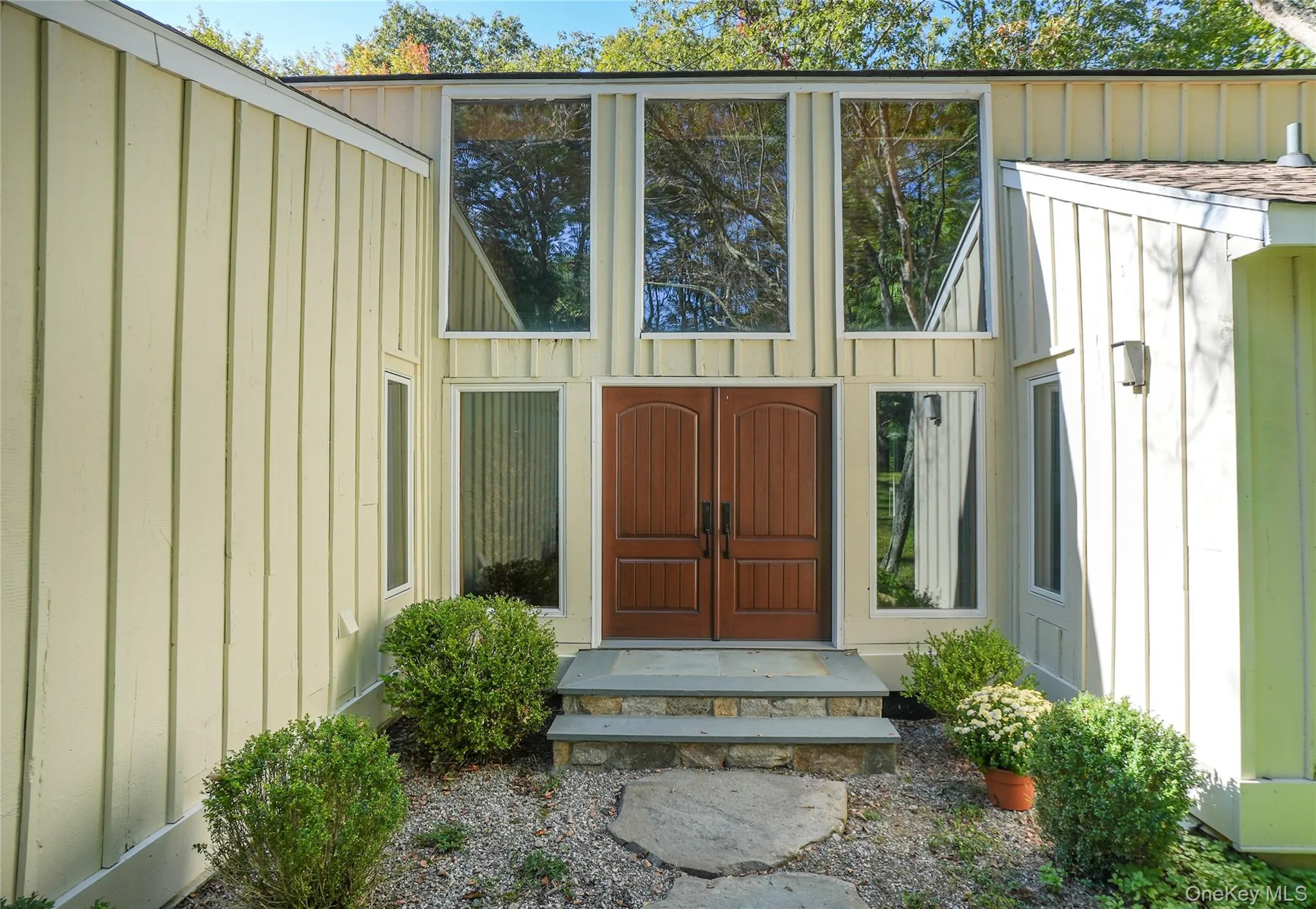 Contemporary facade featuring vertical siding and an expansive window array Contemporary facade featuring vertical siding and an expansive window array