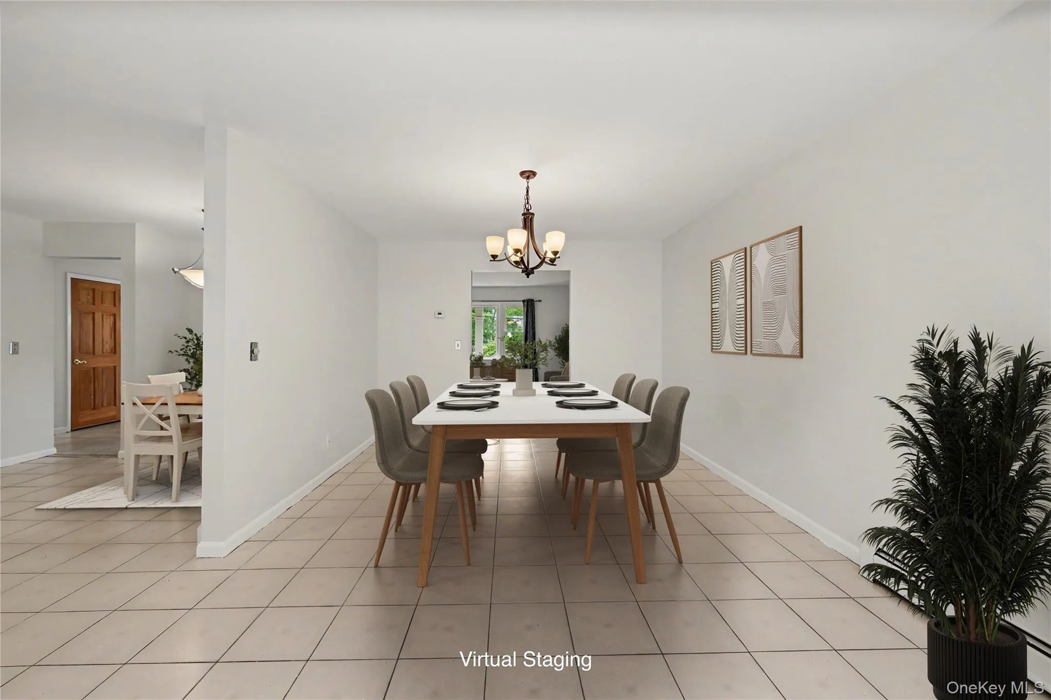 Virtually staged spacious room featuring neutral tile flooring, light neutral wall paint, and a multi-arm chandelier. Eat-in Kitchen is to the left. Virtually staged spacious room featuring neutral tile flooring, light neutral wall paint, and a multi-arm chandelier. Eat-in Kitchen is to the left.