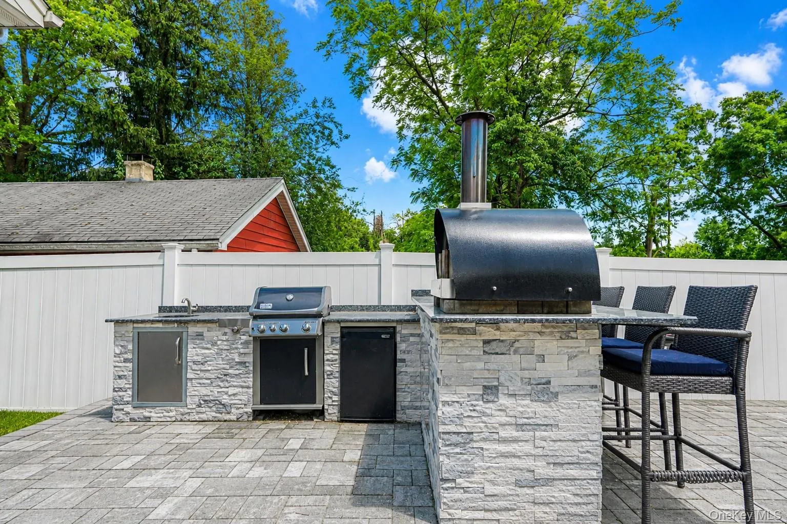 Outdoor kitchen featuring a built-in grill, integrated sink, and an outdoor oven Outdoor kitchen featuring a built-in grill, integrated sink, and an outdoor oven