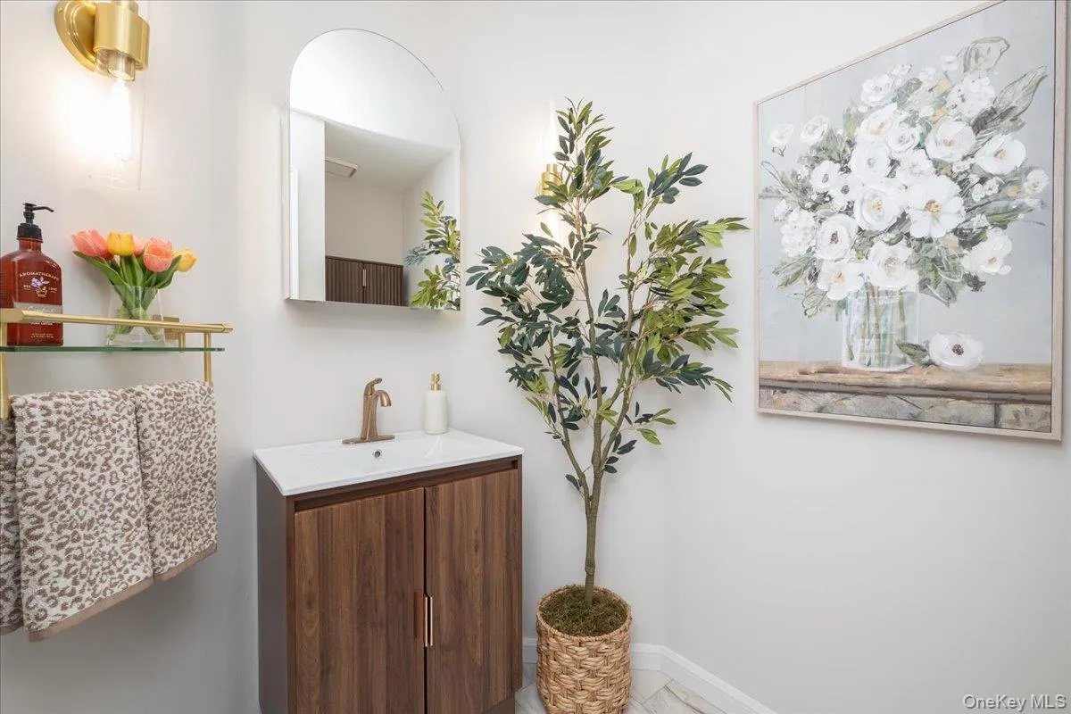 Powder Room, Modern vanity with integrated sink, brass-finish faucet, and wood-finish cabinetry Powder Room, Modern vanity with integrated sink, brass-finish faucet, and wood-finish cabinetry