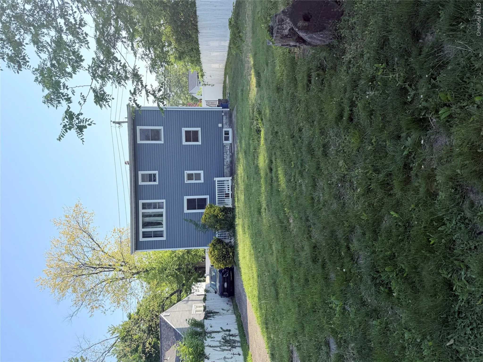 Exterior showcasing blue horizontal siding, white trim windows, and a white picket fence Exterior showcasing blue horizontal siding, white trim windows, and a white picket fence