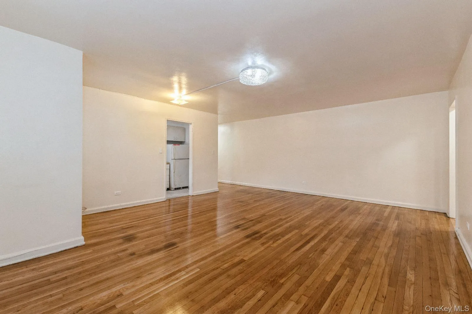 Spare room featuring baseboards and light wood-style floors Spare room featuring baseboards and light wood-style floors