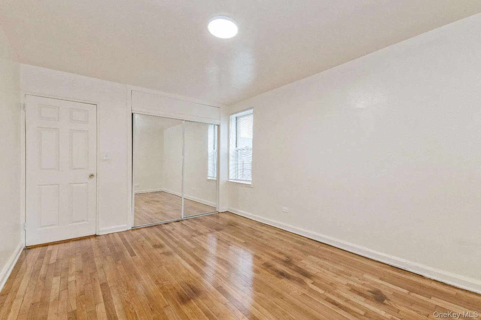 Unfurnished bedroom with baseboards, a closet, and light wood-style floors Unfurnished bedroom with baseboards, a closet, and light wood-style floors