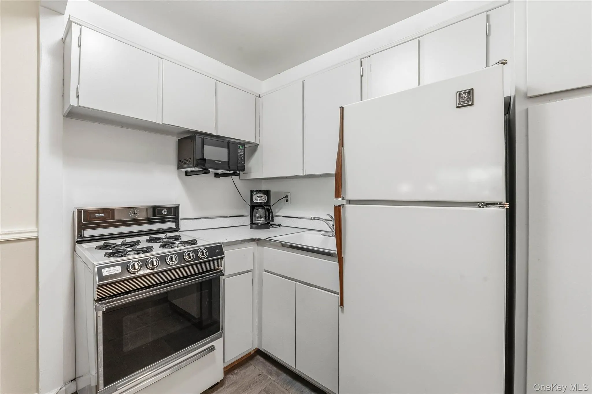 Kitchen featuring white cabinetry and countertops Kitchen featuring white cabinetry and countertops
