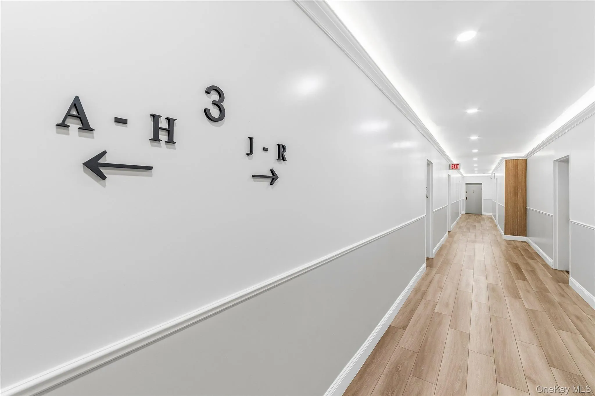 Hallway featuring wood-finish flooring, recessed ceiling lighting, and crown molding Hallway featuring wood-finish flooring, recessed ceiling lighting, and crown molding