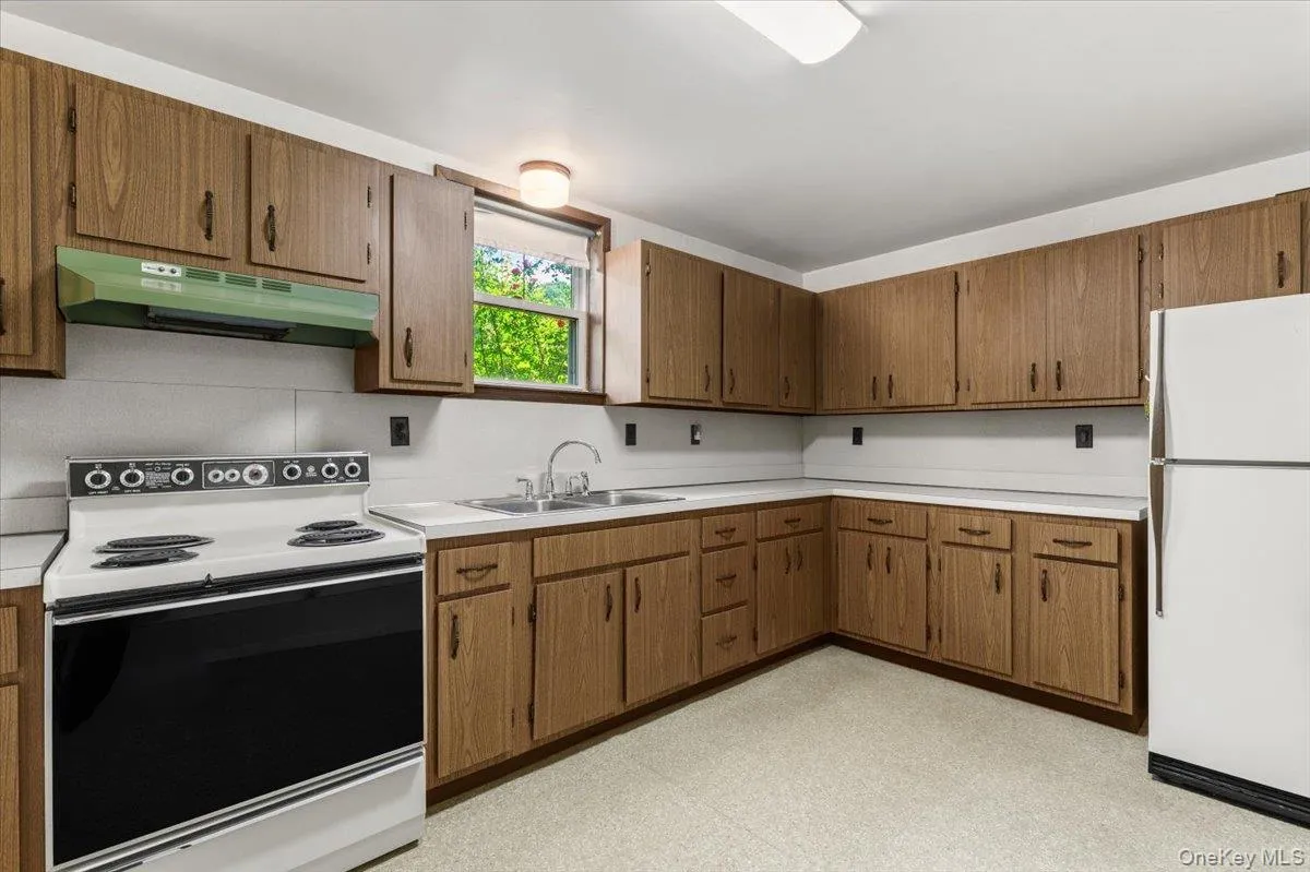 A practical kitchen with generous cabinet storage, ample prep space, and a bright window overlooking the property. A practical kitchen with generous cabinet storage, ample prep space, and a bright window overlooking the property.