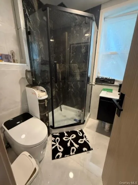 Full bath with a marble finish shower and toilet Full bath with a marble finish shower and toilet