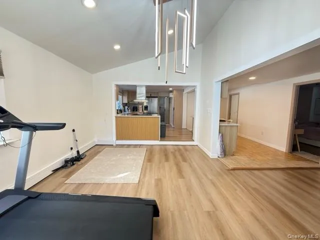 Workout room featuring recessed lighting, light wood finished floors, and high vaulted ceiling Workout room featuring recessed lighting, light wood finished floors, and high vaulted ceiling