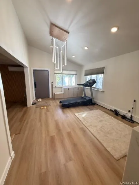 Exercise room featuring vaulted ceiling, wood finished floors, and recessed lighting Exercise room featuring vaulted ceiling, wood finished floors, and recessed lighting