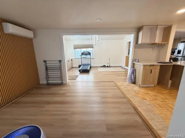 Unfurnished dining area featuring light wood finished floors and a wall mounted AC Unfurnished dining area featuring light wood finished floors and a wall mounted AC