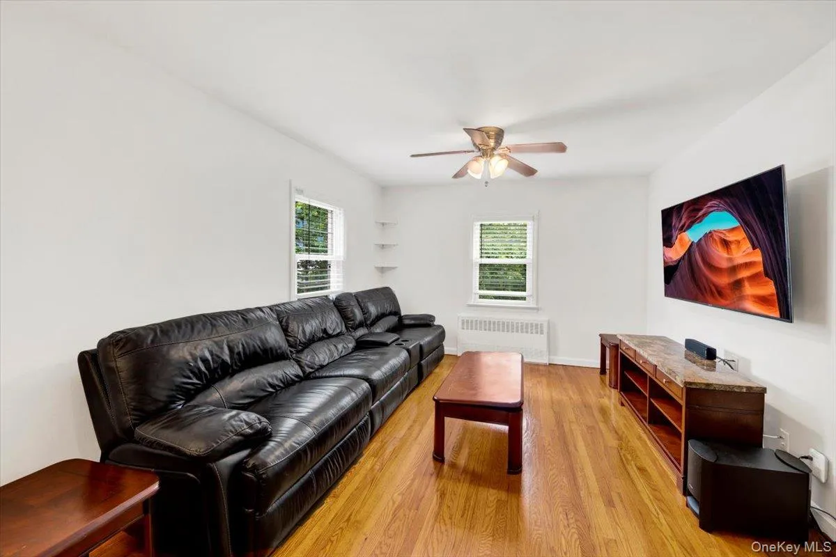 Living area featuring ceiling fan and light wood flooring Living area featuring ceiling fan and light wood flooring