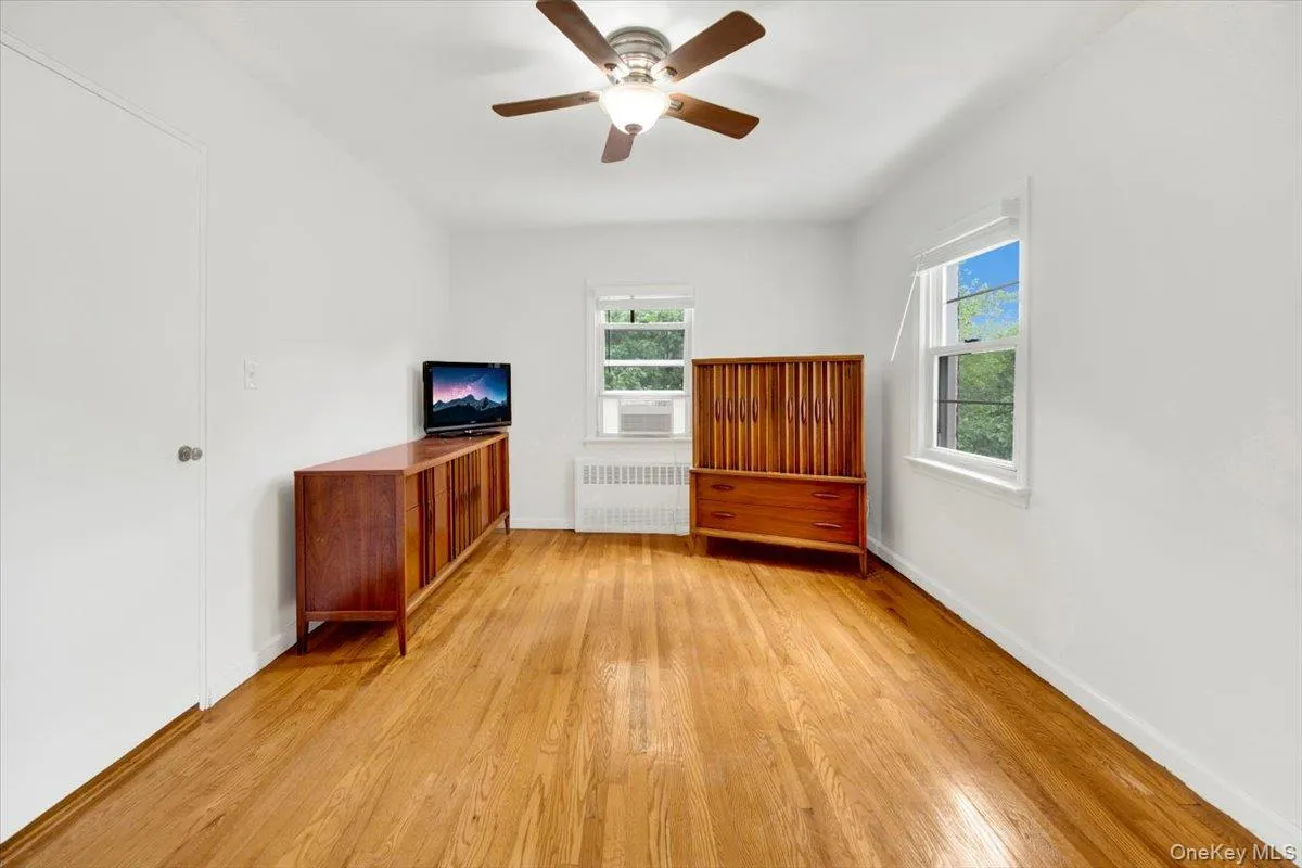 Unfurnished bedroom with light wood flooring, ceiling fan and spacious closet Unfurnished bedroom with light wood flooring, ceiling fan and spacious closet