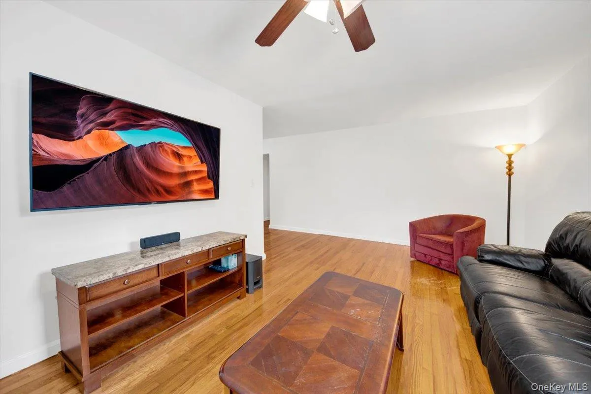 Living area featuring ceiling fan and light wood flooring Living area featuring ceiling fan and light wood flooring