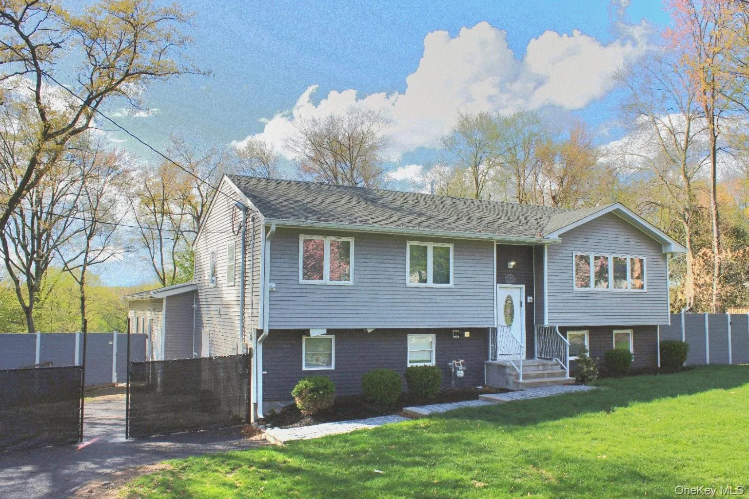 Split-level residence featuring gray siding and a contrasting dark lower level Split-level residence featuring gray siding and a contrasting dark lower level