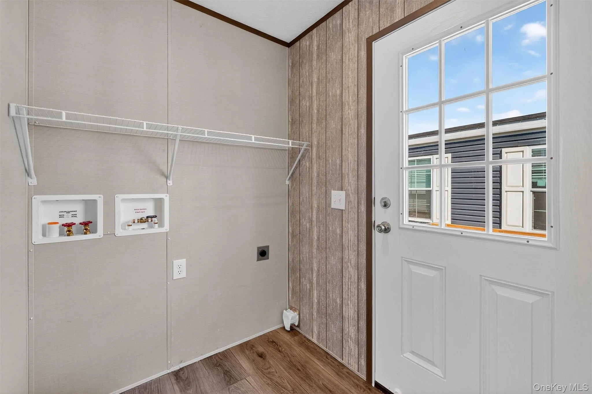 Washroom with wood finished floors, washer hookup, hookup for an electric dryer, and ornamental molding Washroom with wood finished floors, washer hookup, hookup for an electric dryer, and ornamental molding