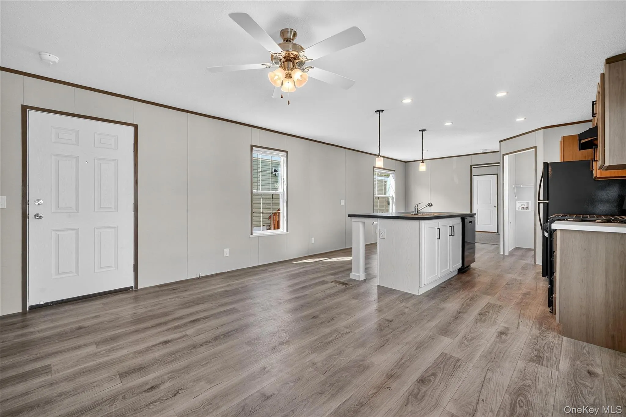 Kitchen with crown molding, light wood-style floors, a center island with sink, decorative light fixtures, and range Kitchen with crown molding, light wood-style floors, a center island with sink, decorative light fixtures, and range