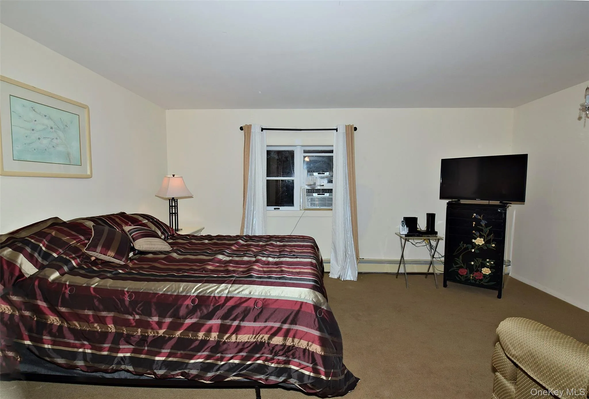 Carpeted bedroom with baseboards, cooling unit, and baseboard heating Carpeted bedroom with baseboards, cooling unit, and baseboard heating
