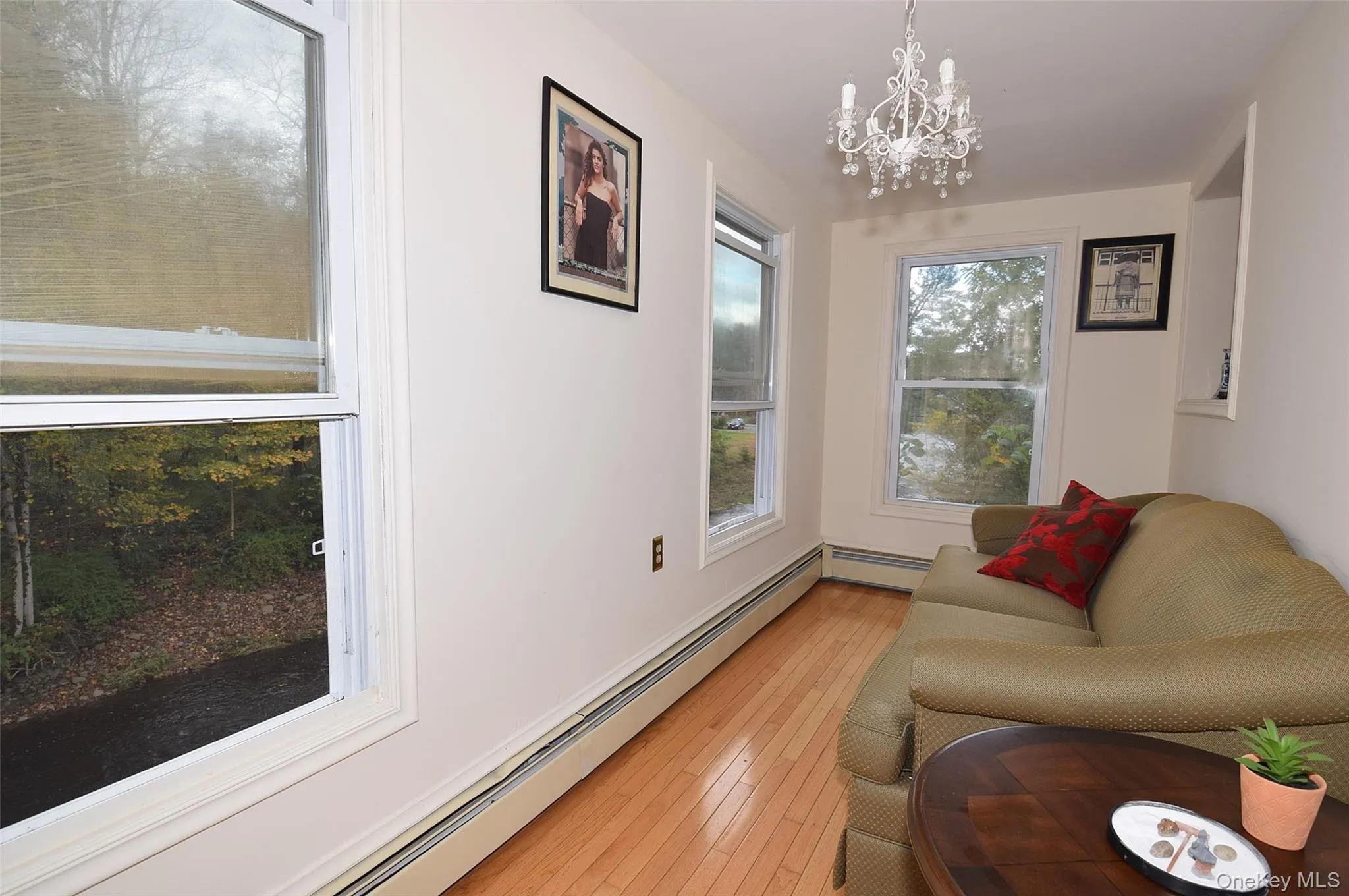 Sitting room featuring a chandelier, light wood-style flooring, and baseboard heating Sitting room featuring a chandelier, light wood-style flooring, and baseboard heating