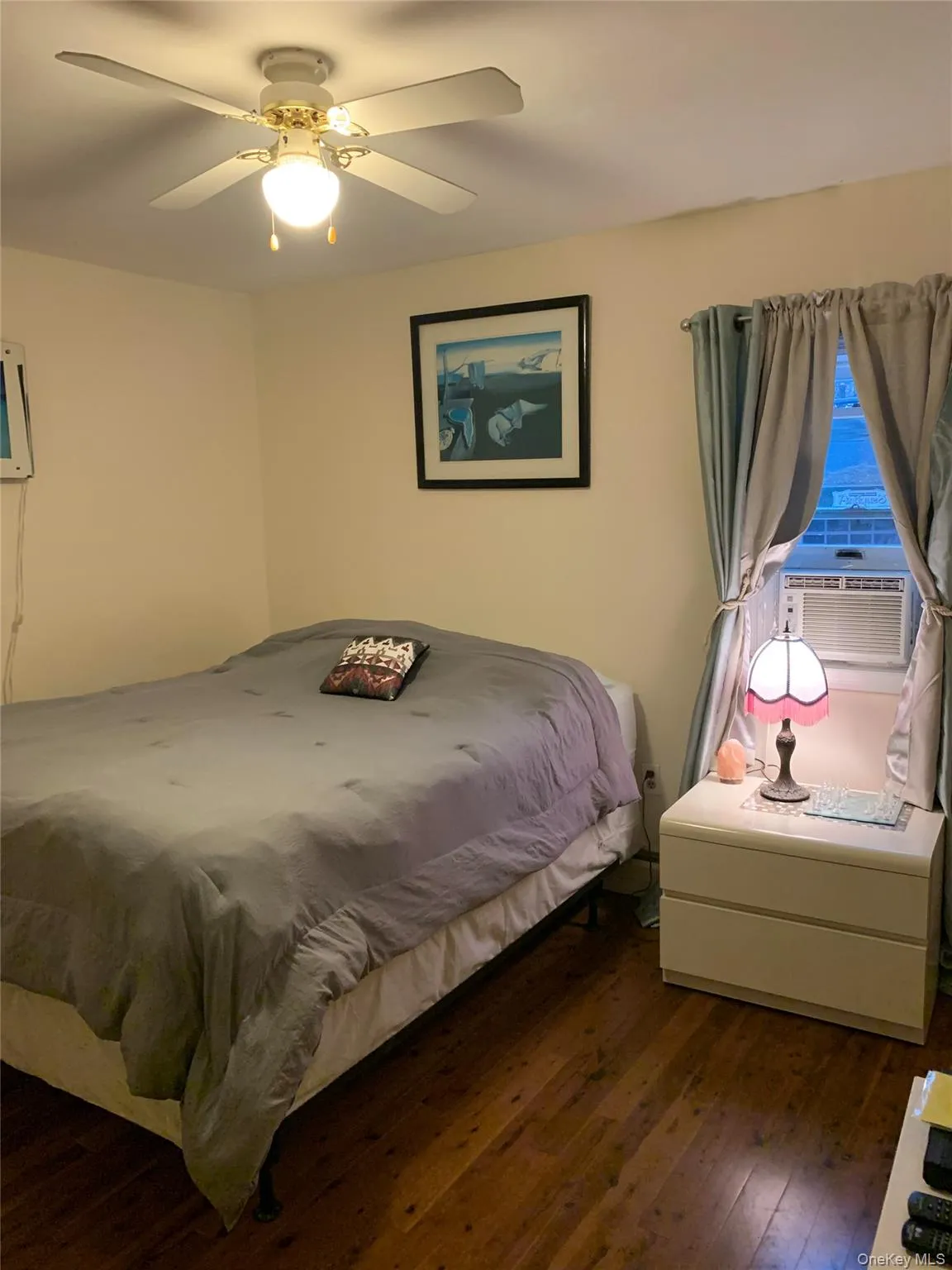 Bedroom featuring hardwood / wood-style floors, cooling unit, and a ceiling fan Bedroom featuring hardwood / wood-style floors, cooling unit, and a ceiling fan