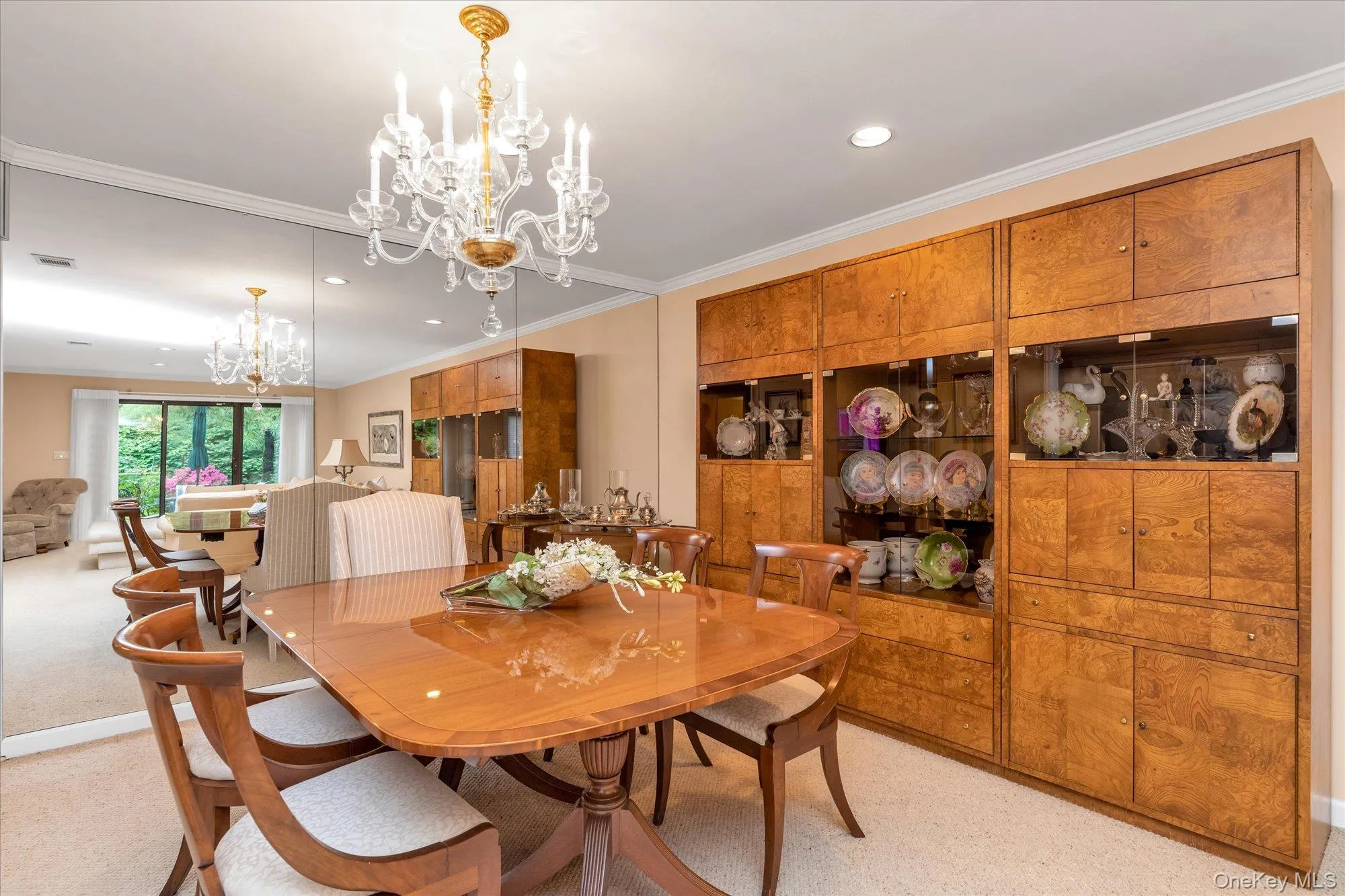 Dining area featuring a clear crystal chandelier, extensive mirrored wall, recessed lighting, and wall-to-wall carpeting Dining area featuring a clear crystal chandelier, extensive mirrored wall, recessed lighting, and wall-to-wall carpeting