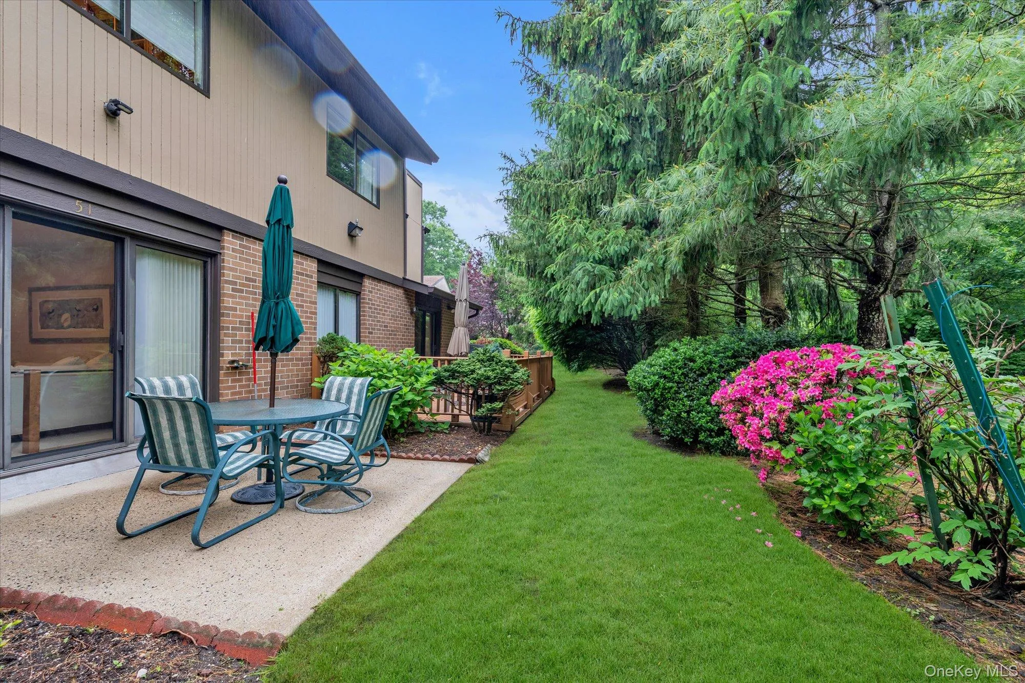 Private patio with a textured concrete surface, offering direct access via sliding glass doors Private patio with a textured concrete surface, offering direct access via sliding glass doors