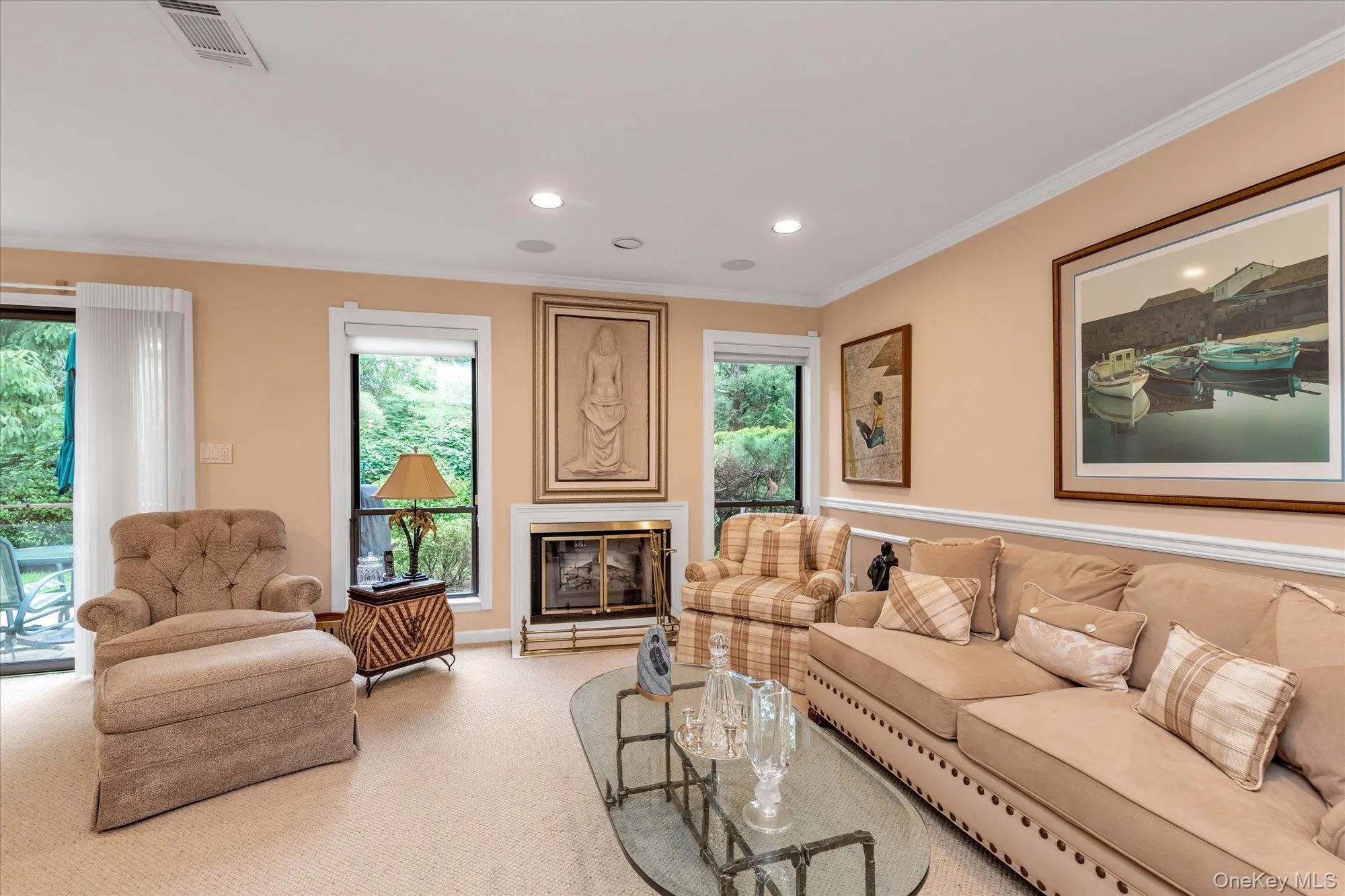 Living area featuring a fireplace with brass accents, recessed lighting, and wall-to-wall carpeting Living area featuring a fireplace with brass accents, recessed lighting, and wall-to-wall carpeting