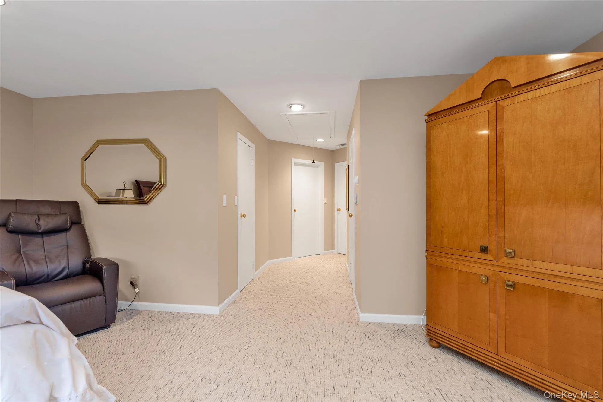 Primary bedroom featuring two large walk in closets, recessed lighting, carpeting and neutral wall tones Primary bedroom featuring two large walk in closets, recessed lighting, carpeting and neutral wall tones
