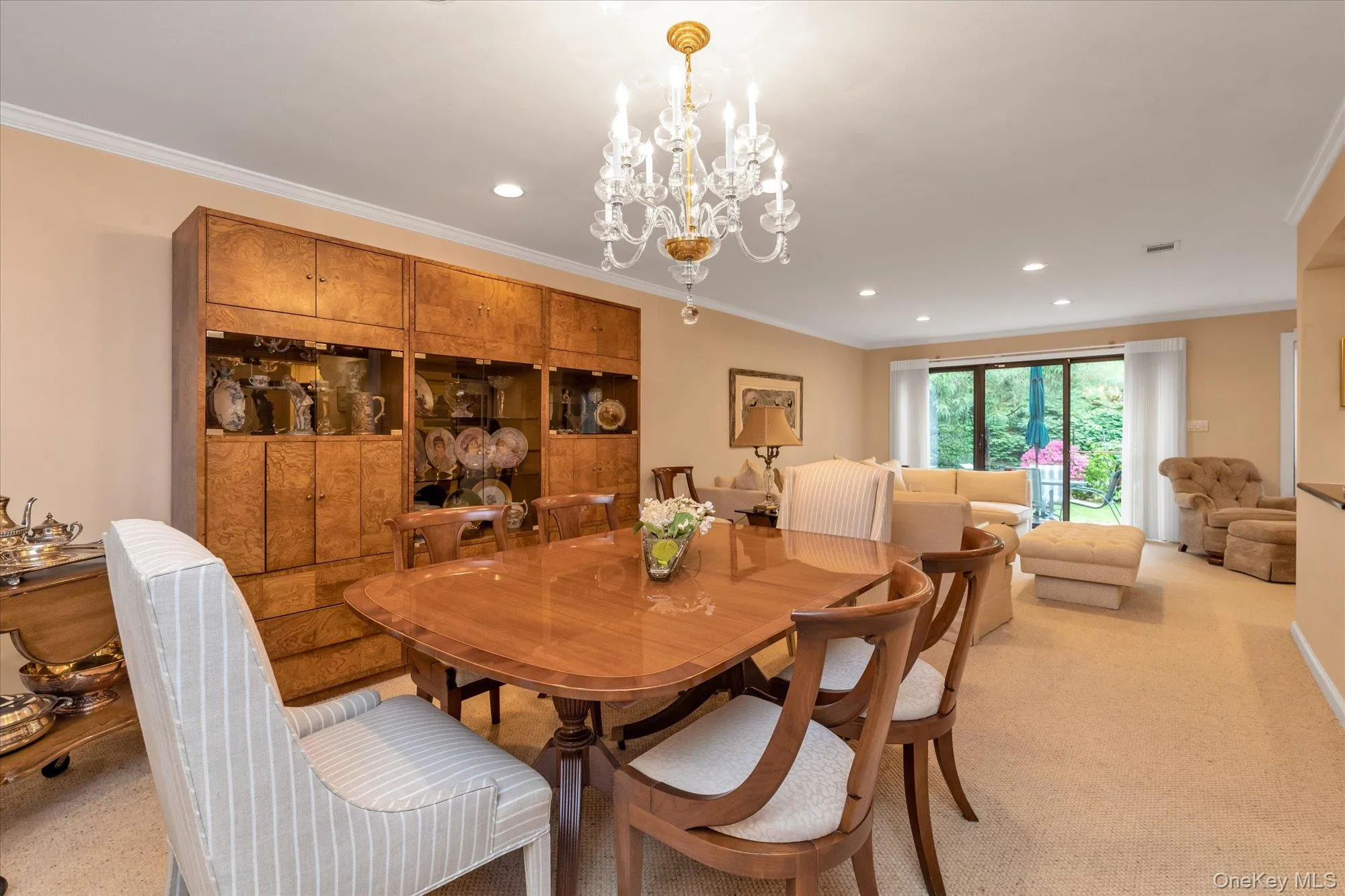 Dining area featuring a crystal chandelier, recessed lighting, and a built-in wood display cabinet Dining area featuring a crystal chandelier, recessed lighting, and a built-in wood display cabinet