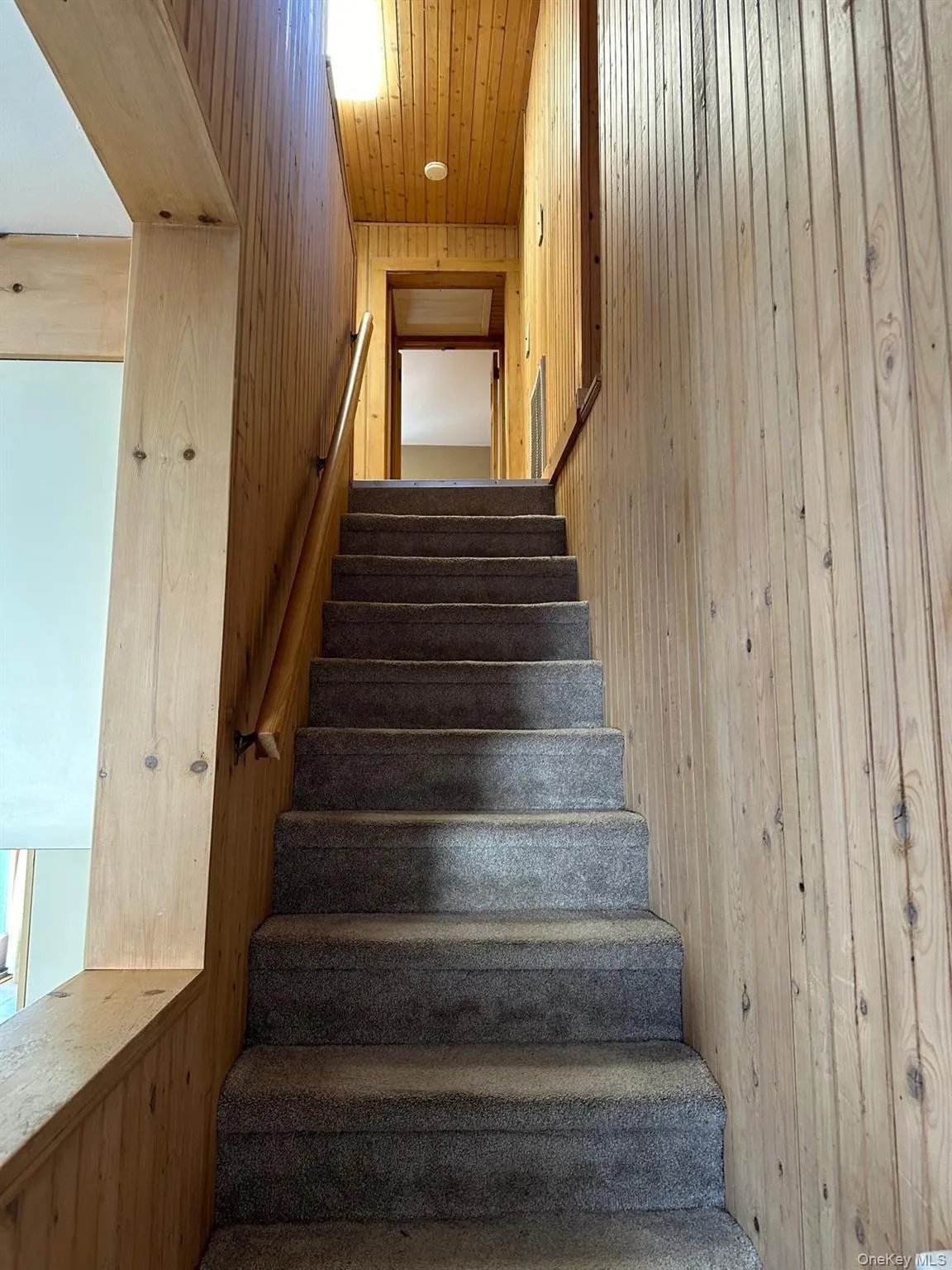 Stairway featuring wood ceiling and wooden walls leading to 2nd floor Stairway featuring wood ceiling and wooden walls leading to 2nd floor